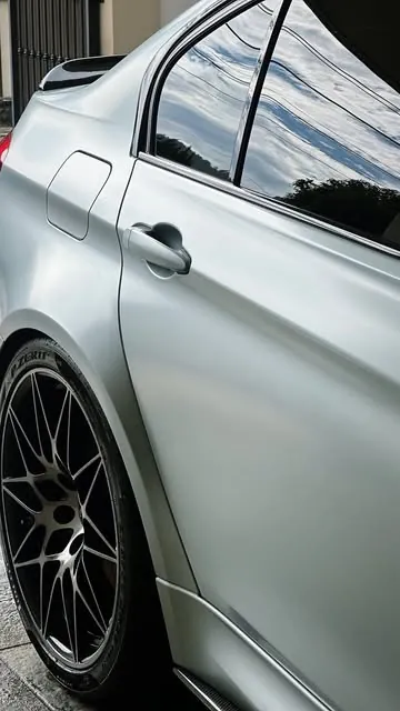 Satin grey BMW sedan with dark alloy wheels after a detail